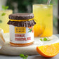 Jar of Native Tongue Orange Marmalade with oranges and a drink in the background